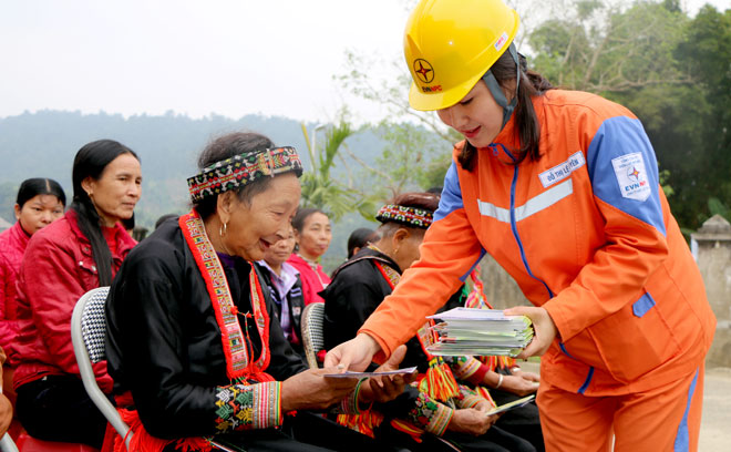 Cán bộ Công ty Điện lực Yên Bái phát tờ rơi tuyên truyền tiết kiệm diện đến người dân huyện Lục Yên