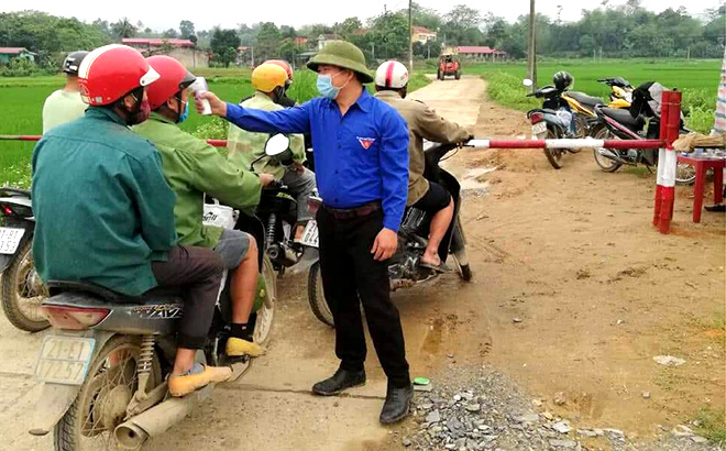 Mọi người dân đều được đo thân nhiệt và khai báo y tế trước khi vào thôn, xã.