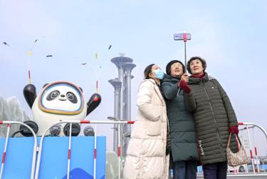 Người dân chụp ảnh trước linh vật Thế vận hội mùa Đông Bắc Kinh và Tháp Olympic ở Bắc Kinh hôm 19/1.