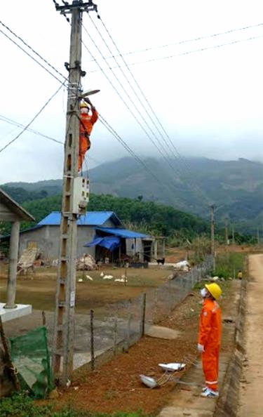Công nhân Điện lực Lục Yên kéo dây và lắp điện chiếu sáng đường quê tại thôn 4, xã Khánh Hòa.
