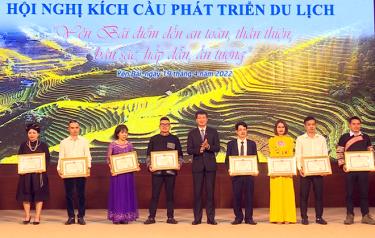 Chairman of the Yen Bai People’s Committee Tran Huy Tuan presents certificates of merit to six collectives and four individuals for their outstanding contributions in carrying out tourism activities in the province for the 2020-21 period.
