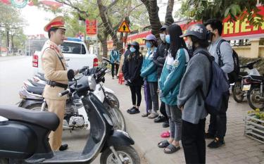 Cán bộ, chiến sĩ CSGT Công an huyện Văn Yên tuyên truyền, nhắc nhở các em học sinh chấp hành luật lệ an toàn giao thông.