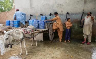 Người dân Jacobabad làm mát thông qua nguồn cung nước uống (can màu xanh) lẫn nước sinh hoạt hạn chế. (Ảnh chụp năm 2021).