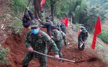 Cán bộ, chiến sĩ lực lượng vũ trang huyện Mù Cang Chải giúp dân làm đường giao thông nông thôn.