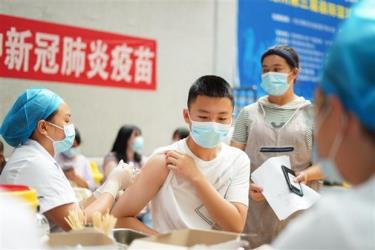 Nhân viên y tế tiêm vaccine ngừa COVID-19 cho học sinh tại Quý Châu (Trung Quốc).