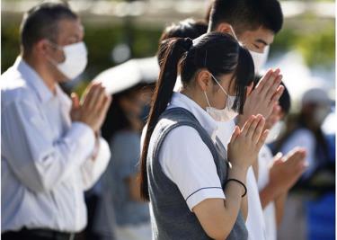 Người dân Nhật Bản đeo khẩu trang khi cầu nguyện tại Công viên Hòa bình ở Nagasaki, ngày 8/8/2022 - chỉ một ngày trước dịp tròn 77 năm Mỹ ném bom nguyên tử xuống thành phố này của miền Tây Nam Nhật Bản.