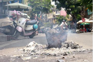 Người dân đốt vàng mã ngay trên đường, cạnh những chiếc xe máy gây nguy cơ cháy nổ và ô nhiễm môi trường.